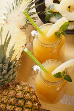 Delicious fresh pineapple juice in a glass jar closeup. vertical