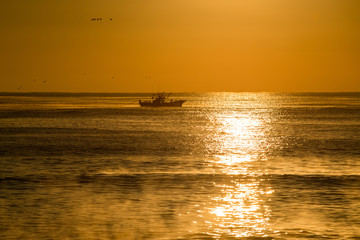 朝焼けの中の漁船