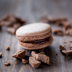 Chocolate macarons on a rustic wooden table. 