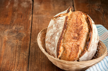 Freshly baked sourdough bread in a basket on a wooden table
