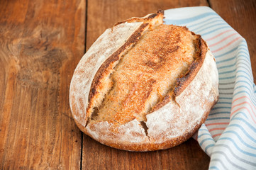 Freshly baked sourdough bread in a basket on a wooden table
