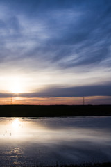 Field, river and beautiful sky and clouds reflected