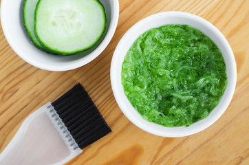 Grated cucumber in a small ceramic bowl for preparing natural facial mask. Homemade cosmetics.
