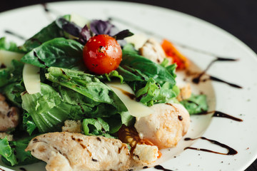 Caesar salad with chicken on white dish