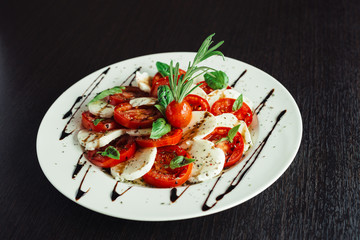 Appetizer with feta and tomatoes on dish