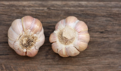 Garlic bulb and cloves on wooden background.