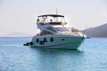 Fototapeta na wymiar Luxury yacht in azure seas parked in a beautiful blue bay. Modern white Yacht in the sea around island on Croatia.