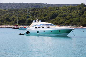 Fototapeta na wymiar Luxury yacht in azure seas parked in a beautiful blue bay. Modern white Yacht in the sea around island on Croatia.