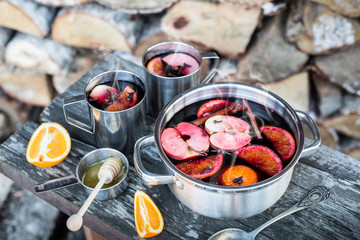 Hot mulled wine outdoor in a pot - winter or autumn picnic