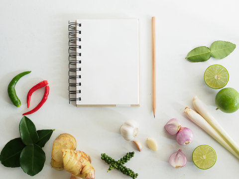 Top view notebook and pencil with organic vaious vegetable on wh
