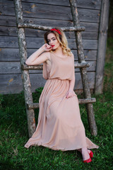 Obraz premium Yong elegance blonde girl at rose dress on the garden background