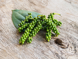 Fresh green peppercorn with leaf on old wooden