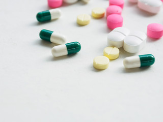 various medicine pill and capsule on white desk background