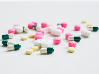 Colorful medicine pill and capsule on white desk