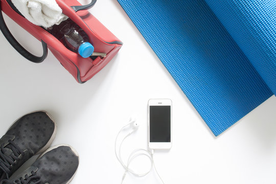 Overhead view of sport equipment and smartphone on blue yoga mat