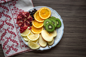 Sliced fruit: apple, pomegranate, orange, kiwi, lemons