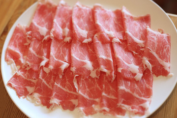 Raw pork sliced in white dish for shabushabu, Japanese recipe.