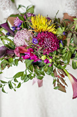 Brides bouquet of autumn flowers in burgundy tones.