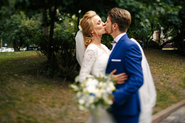 Fototapeta premium Passionate kiss of wedding couple greeting each other on the pat