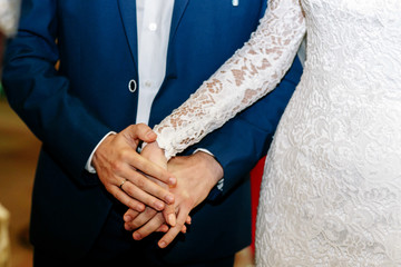 Obraz premium Groom holds tender bride's hand standing by her side