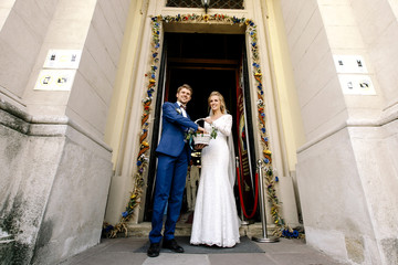 Naklejka premium Bride holds white basket while groom takes sweets from it