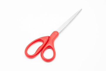 Red scissors on white background
