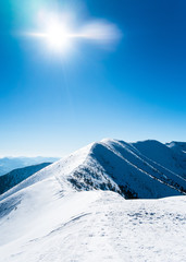 Snowy mountains with sun, beautiful european mountains, symbol of winter mountains, comb winter mountain, alpine mountain peak, ridge of mountains, beautiful snowy landscape