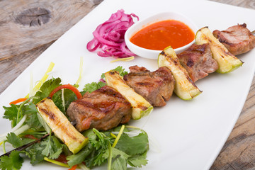 Fried meat on a metal skewer