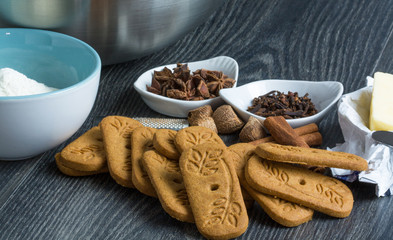 Spéculoos en tas et ingrédients de fabrication sur fond sombre