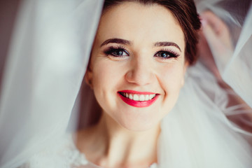 The smilling bride stands in the center of room