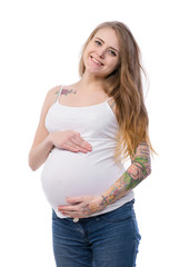 Studio portrait of beautiful young pregnant woman posing on white background. Smiling pregnant blonde