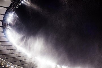 against the background of a sports stadium floodlights, flying snow