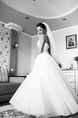 The charming bride stands in the center of room