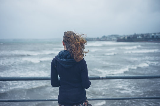 Young woman by the sea on stormy day