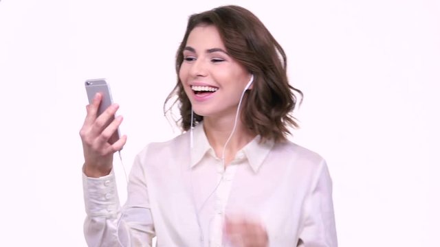 Smiling young woman waving hand during video call on mobile phone isolated on a white background