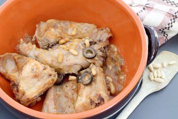 Rabbit meat with olives and pine nuts