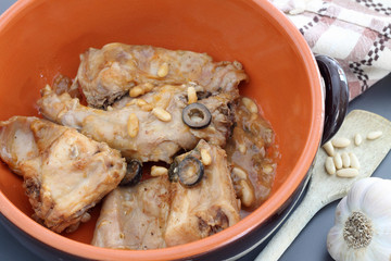 Rabbit meat with olives and pine nuts