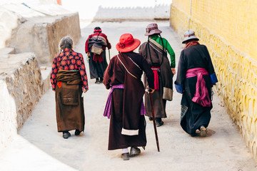 Qinghai, China - 8 October 2016: Local ladies in tibetan clothes - chuba and  colorful hats in buddhist Longwu (Rongwo) Monastery in Qinghai, China