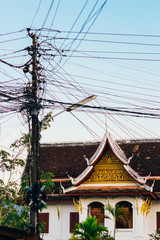 The details of architecture style of a buildings in Luang Prabang, Laos and messy electric wires.