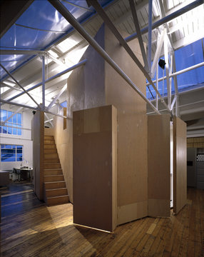 Modern office in old factory with metal roof trusses and shuttering plywood intervention