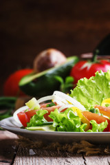 Salad with avocado, salmon, lettuce, onions and peppers on a pla