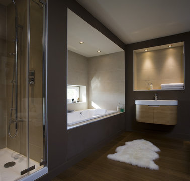 Brown and natural toned bathroom with recessed bathtub in a carbon neutral home 