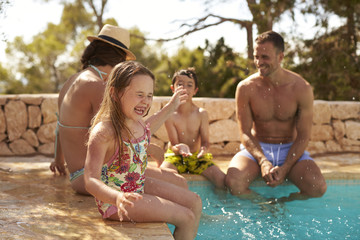 Family On Vacation Having Fun By Outdoor Pool