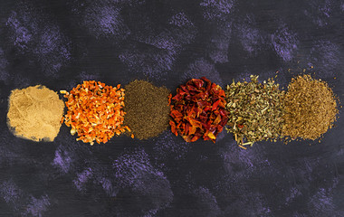 Different spices on dark background. Top view