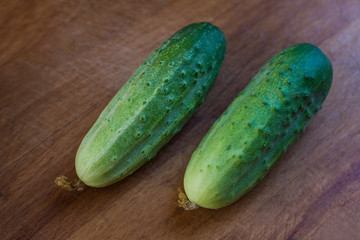 Two green cucumbers on the cutting board before cooking