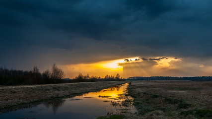 mystical sunset. sunshine light the earth because of dark clouds