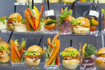 Mini desserts and meat canapes vegetable snacks in plastic cups canapes