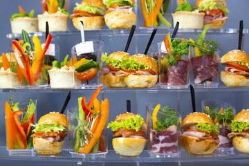 Mini desserts and meat canapes vegetable snacks in plastic cups canapes