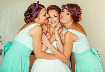 The bridesmaids embracing her bride