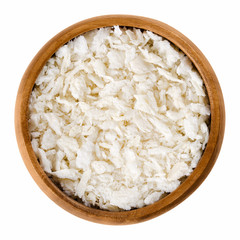 Panko flakes of bread crumbs in wooden bowl. Japanese variety of breadcrumbs, breading or crispies. Dry bread used for making crisp and crunchy covering for fried food. Isolated macro photo over white